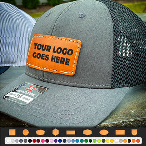 A Richardson 112 Snapback Trucker Cap - Custom Leather Patch Hat | No Minimals | Volume Tiered Pricing with a logo on it.