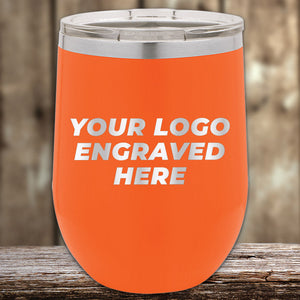 Bright orange Kodiak Coolers tumbler featuring a stainless steel lid with "Your Logo Engraved Here" text in gray on a blurred wooden background. This laser-etched, no-setup-fees custom tumbler is an ideal corporate promotional gift to stylishly showcase your brand.