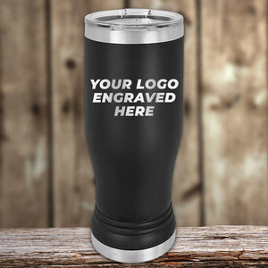 A black insulated tumbler with silver accents stands on a wooden surface. The text "Custom Pilsner Tumblers 14 oz with your Logo or Design Engraved | No Minimal Order | Sample Volume Pricing" by Kodiak Coolers is prominently displayed on the tumbler. The background is a blurred wooden texture.
