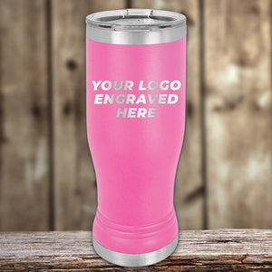 Pink insulated tumbler with a silver lid and the text "YOUR LOGO ENGRAVED HERE" displayed on its surface, set against a rustic wooden background. Ideal for promotional events, this tumbler offers bulk wholesale pricing, making it a perfect match alongside our Kodiak Coolers Custom Pilsner Tumblers 14 oz with your Logo or Design Engraved | No Minimal Order | Sample Volume Pricing collection.