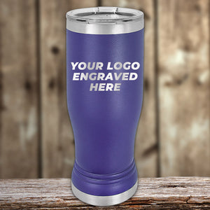 A blue stainless steel tumbler with the text "YOUR LOGO ENGRAVED HERE" printed on it, placed on a wooden surface with a blurred wooden background. Ideal for businesses seeking bulk wholesale pricing or Custom Pilsner Tumblers 14 oz with your Logo or Design Engraved from Kodiak Coolers | No Minimal Order | Sample Volume Pricing for special occasions.