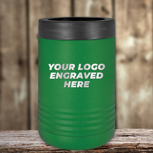 A green Kodiak Coolers insulated tumbler with a black lid rests on a wooden surface. Ideal as a corporate promo gift, this custom tumbler showcases the text "Your Logo Engraved Here" in white letters.