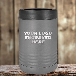 A gray insulated tumbler from Kodiak Coolers rests on a wooden surface, featuring "Your Logo Engraved Here." This laser-etched custom tumbler is an ideal corporate promotional gift, available with no setup fees and as a limited-time offer.