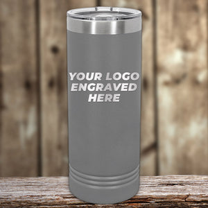 The Kodiak Coolers custom gray tumbler with laser-etched "Your Logo Engraved Here" is ideal for corporate gifts. It's elegantly displayed on a wooden surface against a blurred wooden backdrop.