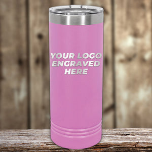 The Kodiak Coolers pink insulated tumbler, ideal as a corporate gift, boasts "Your Logo Engraved Here" on a wooden surface with a gently blurred wood backdrop, highlighting the charm of these custom laser-etched tumblers. No setup fees; limited time offer.