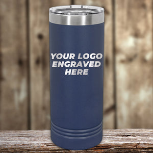 A navy blue Kodiak Coolers insulated tumbler elegantly sits on a wooden surface with "YOUR LOGO ENGRAVED HERE" on the front. These Custom Tumblers offer style and functionality, making them an ideal corporate promotional gift.