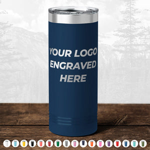 A navy blue tumbler from Kodiak Coolers is placed on a wooden surface, featuring the text "YOUR LOGO ENGRAVED HERE." This ideal promotional gift is available in various colors and requires a minimal order of $250. It includes one side logo engraving with no setup fee as part of the BLACK FRIDAY SALE for custom drinkware.