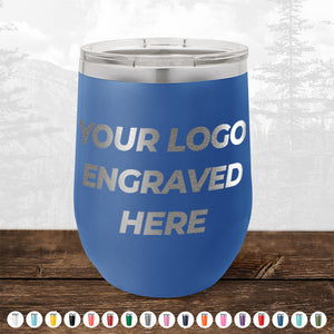 A blue insulated tumbler with the text "4th of July SALE - Engraved Custom Logo Drinkware - Front Engraved Logo Included - $250 Minimal Order" displayed on it. It is placed on a wooden surface with a mountain background and multiple color options shown below, making it an ideal choice for promotional gifts by Kodiak Coolers.