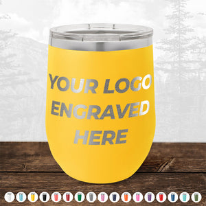 A yellow 4th of July SALE - Engraved Custom Logo Drinkware - Front Engraved Logo Included - $250 Minimal Order with the text "YOUR LOGO ENGRAVED HERE" on the front. The tumbler is on a wooden surface with a natural landscape in the background. Various color options for these personalized mugs from Kodiak Coolers are shown below.