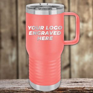 On a wooden surface sits Kodiak Coolers' coral custom tumbler with an engraved logo, ideal for corporate gifts. Featuring "Your Logo Engraved Here" in an elegant laser-etched design, these tumblers are part of a limited-time offer with no setup fees.