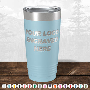 A blue metal tumbler from Kodiak Coolers with "Your Logo Engraved Here" laser etched on it is placed on a wooden surface, accompanied by small icons of custom engraved tumblers in various colors below. These Custom Tumblers with Logo Engraved are ideal as corporate promotional gifts and perfect for bulk wholesale pricing. Take advantage of the FLASH SALE - ENDING SOON! No setup fees and fast turnaround included.