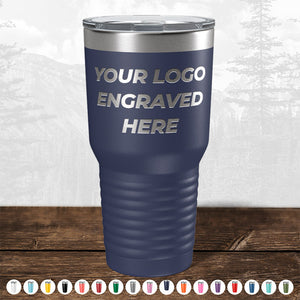 The Custom Drinkware Engraved with your Logo or Design by Kodiak Coolers is a dark blue travel tumbler featuring "YOUR LOGO ENGRAVED HERE" on it. Part of our customizable and personalized mugs collection, this promotional gift comes in various colors showcased below the tumbler. Don’t miss out on our HUGE LABOR DAY SALE - ENDS TODAY!