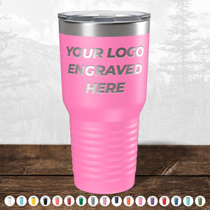 A pink insulated tumbler from Kodiak Coolers, featuring your custom logo or design engraved on the front side. Various color options are showcased at the bottom, against a diffused backdrop of trees and mountains. Perfect as a promotional gift, this item is currently available during our HUGE LABOR DAY SALE – ENDS TODAY!