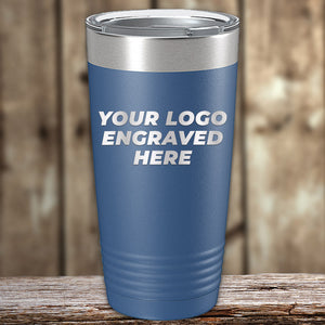 A blue stainless steel tumbler with the text "Your Logo Engraved Here" sits proudly on a wooden surface, against a wooden background. Perfect for those seeking Kodiak Coolers Custom Tumblers 20 oz with your Logo or Design Engraved - Special Bulk Wholesale Pricing - Bundle Packs with laser engraved precision, available at competitive wholesale pricing.