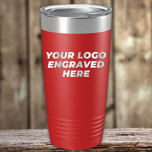 A red insulated tumbler with a silver lid and the text "YOUR LOGO LASER ENGRAVED HERE" written on the side stands on a wooden surface against a blurred wooden background. Perfect for personal or wholesale pricing options, these Custom Tumblers 20 oz with your Logo or Design Engraved - Special Bulk Wholesale Pricing - Bundle Packs by Kodiak Coolers are both stylish and practical.