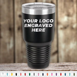 A black tumbler with "YOUR LOGO ENGRAVED HERE" text, displayed against a wooden background. Kodiak Coolers Custom Tumblers 30 oz with your Logo or Design Engraved | No Minimal Order | Sample Volume Pricing in various color options are shown at the bottom—perfect promotional items for your brand.