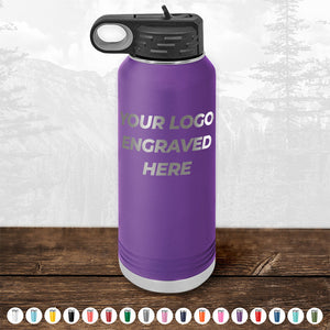 A Kodiak Coolers Custom Drinkware bottle, featuring a purple stainless steel design with "YOUR LOGO ENGRAVED HERE" prominently displayed, sits on a wooden surface surrounded by other vibrant color options, making it an ideal promotional gift for those seeking personalized drinkware. Don't miss out on the HUGE LABOR DAY SALE - ENDS TODAY!