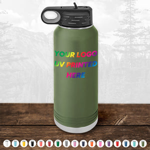 A green, reusable water bottle from Kodiak Coolers featuring a black lid and vibrant rainbow-colored text that reads "YOUR LOGO UV PRINTED HERE" is displayed on a wooden surface with a forest backdrop. Ideal as a corporate promotional gift, this Custom Tumbler offers various color options. Bulk wholesale pricing is available for the Custom Tumblers - UV Printed with your Logo or Design in Full Color, with a limited-time offer of $250 minimal order.