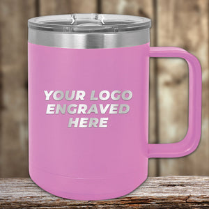 A pink insulated mug from Kodiak Coolers, featuring a silver lid and handle. The front showcases the text "YOUR LOGO ENGRAVED HERE" in metallic letters. These personalized mugs are perfect as an excellent promotional gift, with a wooden background accentuating their elegance. Available now during our SPECIAL 72 HOUR SALE PRICING, with single side engraving included in the price!