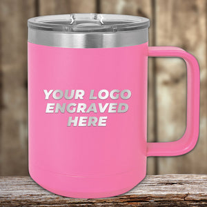 Introducing the Kodiak Coolers Engraved Custom Logo Drinkware - SPECIAL 72 HOUR SALE PRICING. This pink insulated mug with a handle features "YOUR LOGO ENGRAVED HERE" on a wooden surface with a blurred background. Perfect as a promotional gift, these personalized mugs seamlessly combine functionality with style. Single side engraving is included in the price!