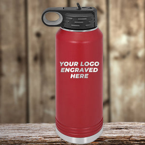 An Engraved Custom Logo Drinkware by Kodiak Coolers, featuring a red insulated water bottle with a black lid and the placeholder text "Your Logo Engraved Here," sits on a wooden surface with a blurred wooden background, making it an ideal promotional gift. Note the special 72-hour sale pricing that includes single side engraving in the price.